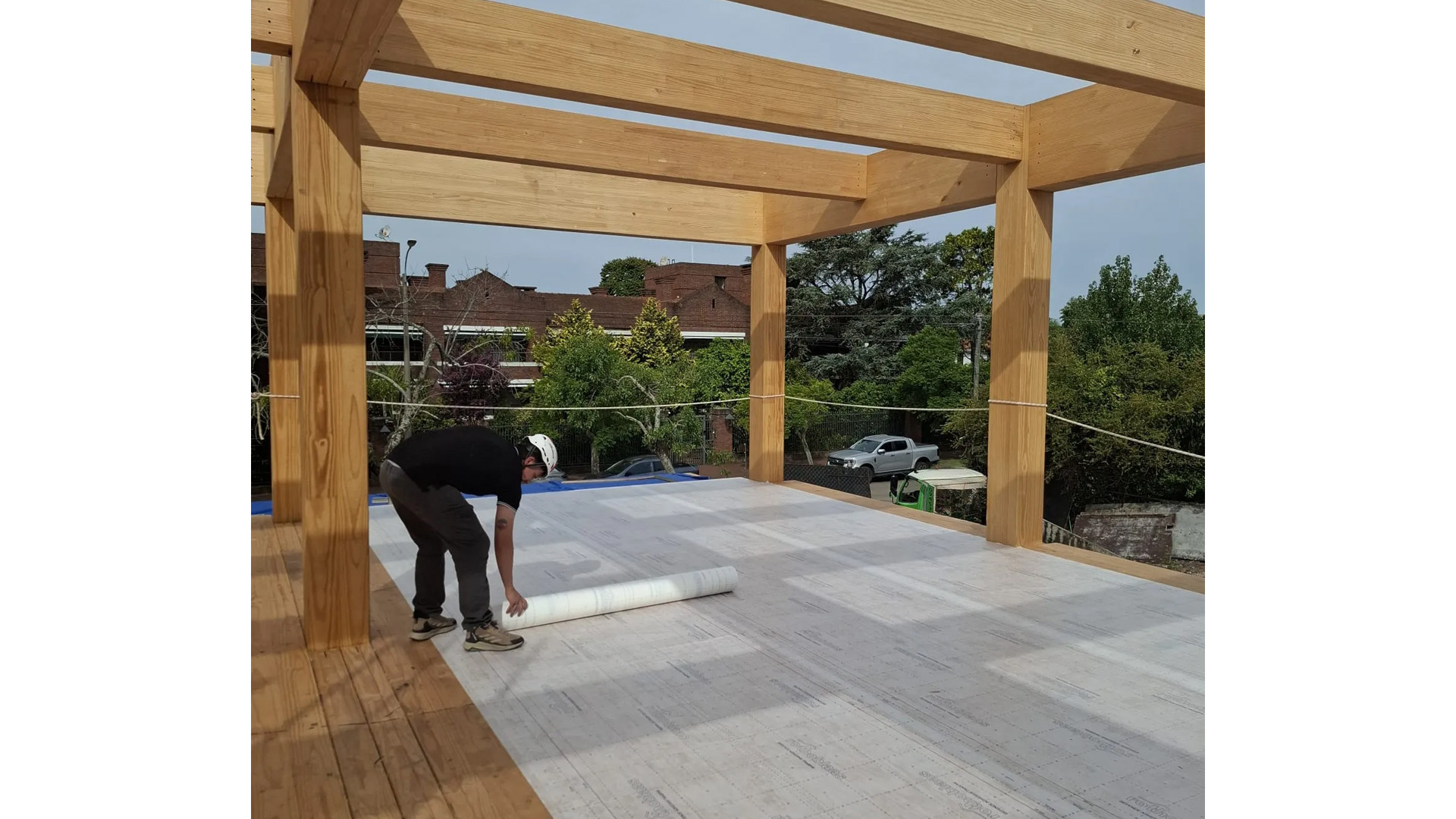 Installation of self-adhesive breathable membrane on CLT floor during mass timber construction for effective timber protection on site. 