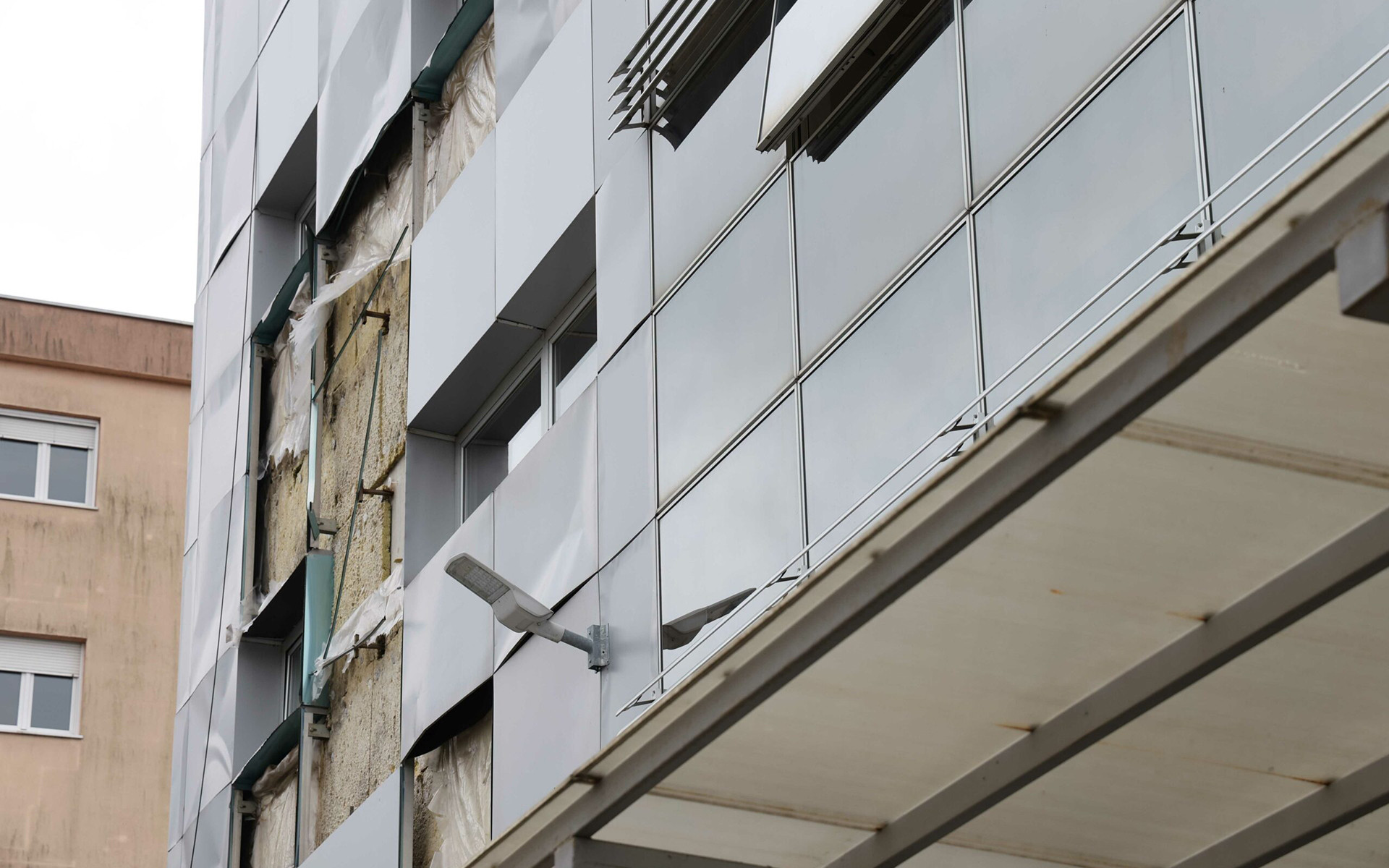  Facciata ventilata danneggiata e isolamento esposto, esempio di degrado dell’involucro edilizio per mancanza di protezione e manutenzione.